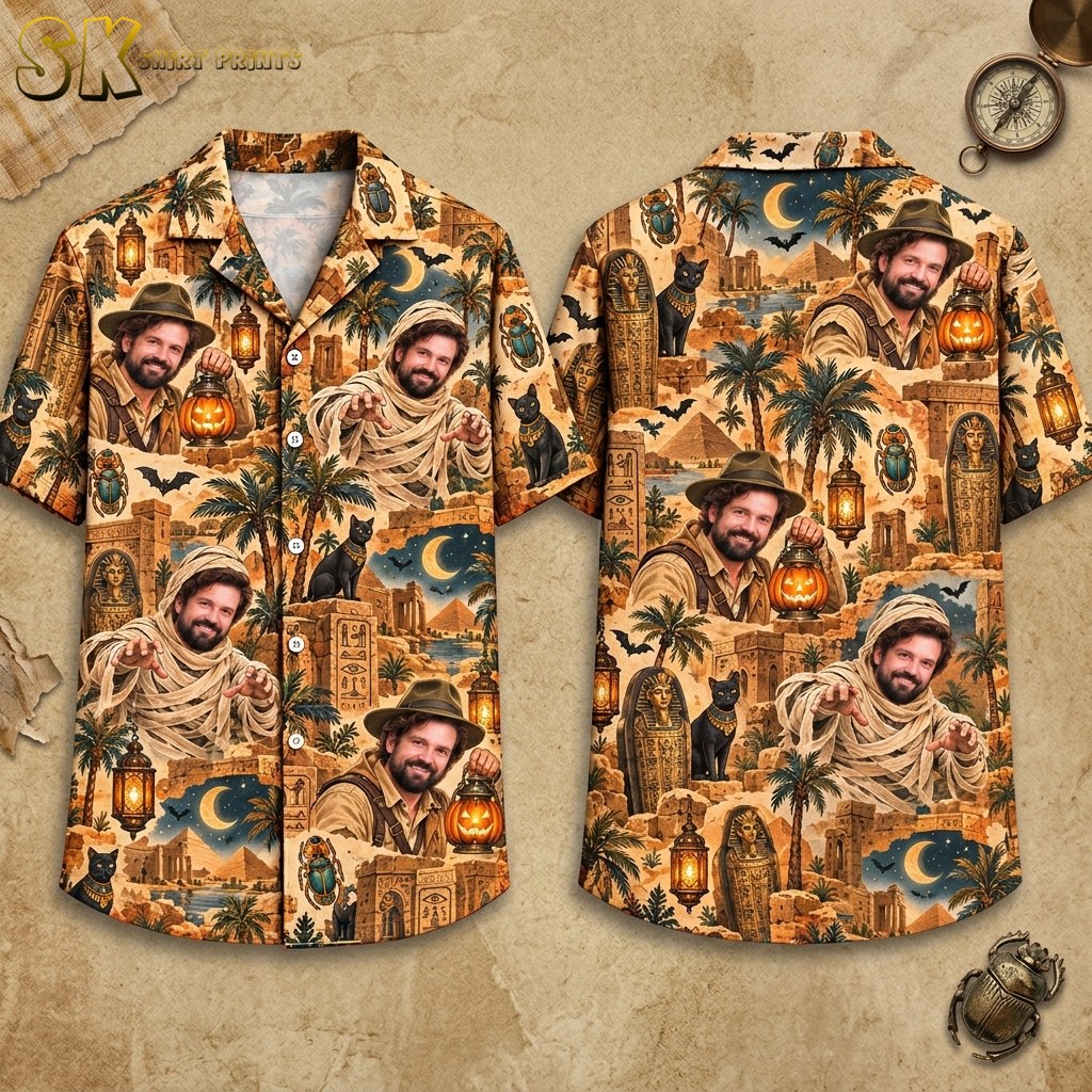 Front and back hanger views of a short-sleeve button-up shirt with a sandy beige base, covered in an all-over pattern of realistic explorer and mummy portraits, Egyptian pyramids, sarcophagi, black cats, bats, and glowing jack-o'-lantern lanterns.
