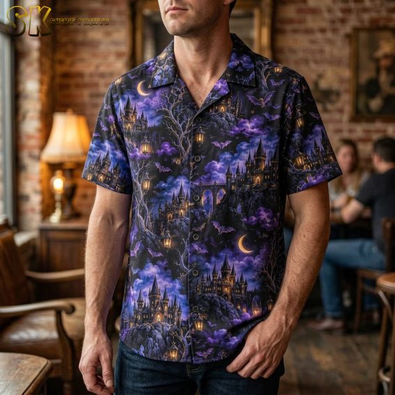 Man wearing a mens halloween hawaiian shirt featuring gothic castles, bats, crescent moons, and glowing lanterns on a dark purple all-over print.