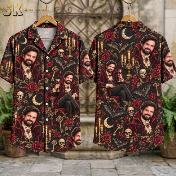Flat-lay view of the shirt showing both front and back panels laid out, with the full all-over pattern of the Victorian vampire figure, gold candelabras, red roses, skulls, and bats clearly displayed against the black base fabric.