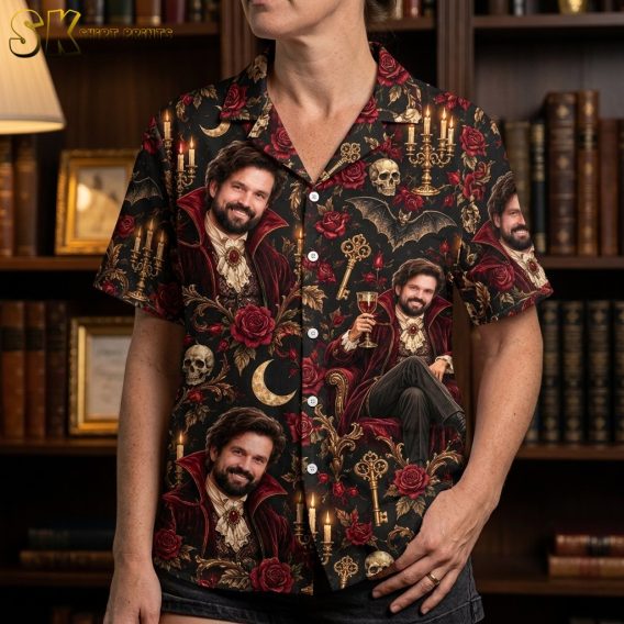 A close-up view of the shirt worn by a woman, showing fine detail in the printed design including the Victorian vampire's ruffled beige shirt, deep red velvet coat, gold brooch, and surrounding crescent moons and black bats.