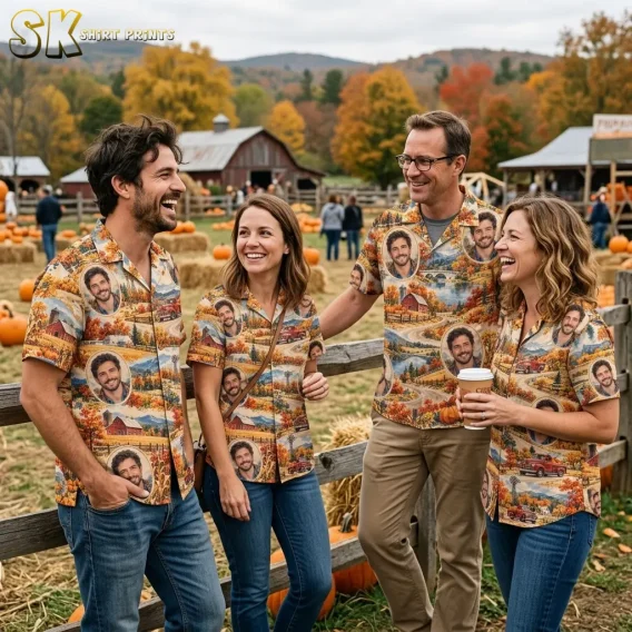 Four smiling adults wear matching fall Hawaiian shirts with portrait and countryside prints beside a wooden fence at a pumpkin patch.