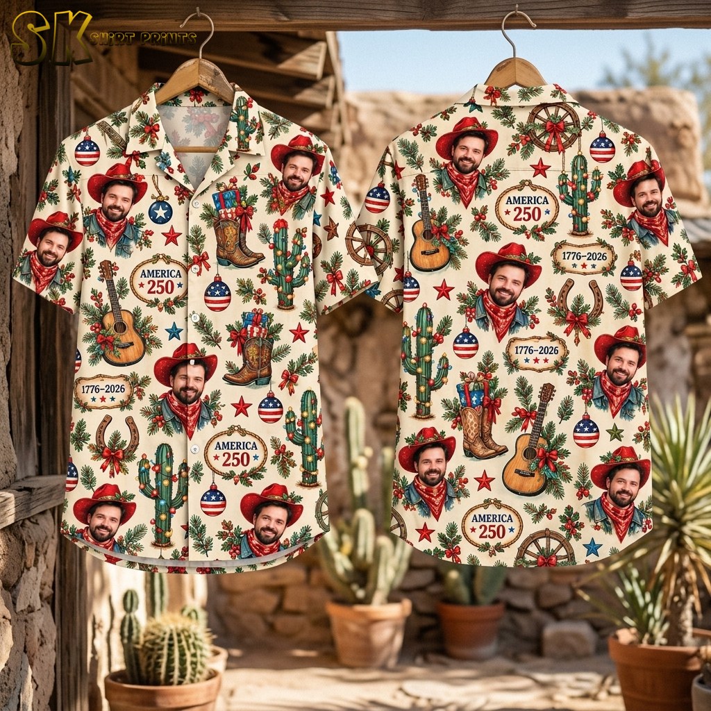 Front and back of the cream short-sleeve shirt hang side by side outdoors in a desert environment with cacti and stone walls, displaying the full all-over pattern of cowboy portraits, boots, guitars, and America 250 plaques on both panels.