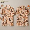 Front and back hanger view of a halloween hawaiian shirt with an all-over pattern of costumed dogs, jack-o'-lanterns, and autumn leaves on a cream base.