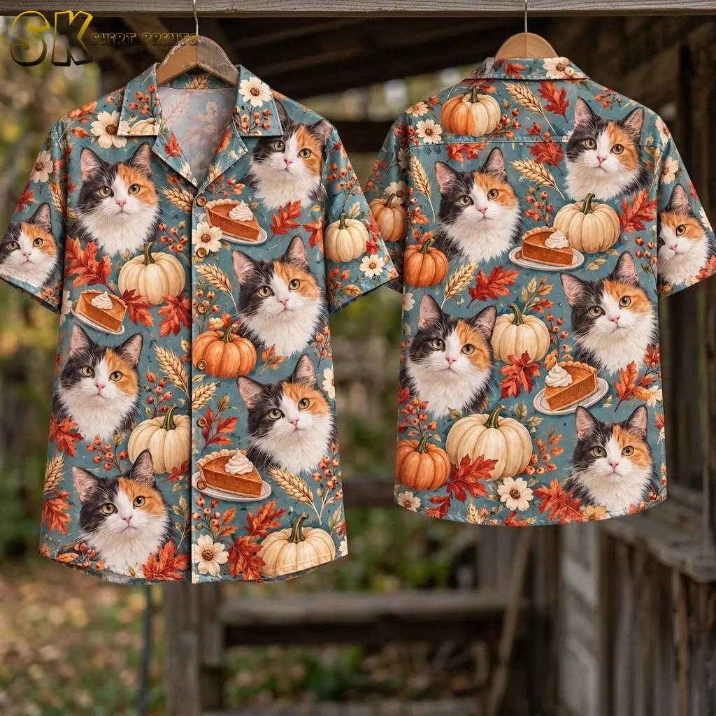 Front and back of a blue calico cat and pumpkin shirt hang from wooden hangers beneath a wooden beam in an outdoor setting.