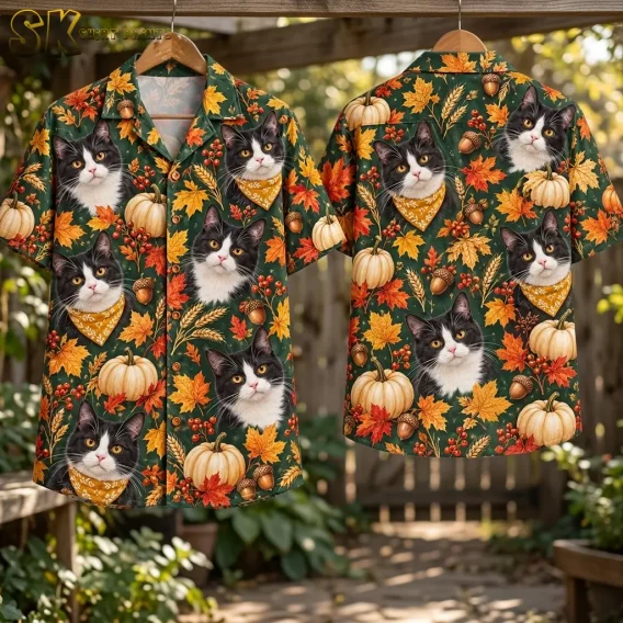 Two green cat-print shirts hang from wooden hangers outdoors, displaying the buttoned front and full patterned back.