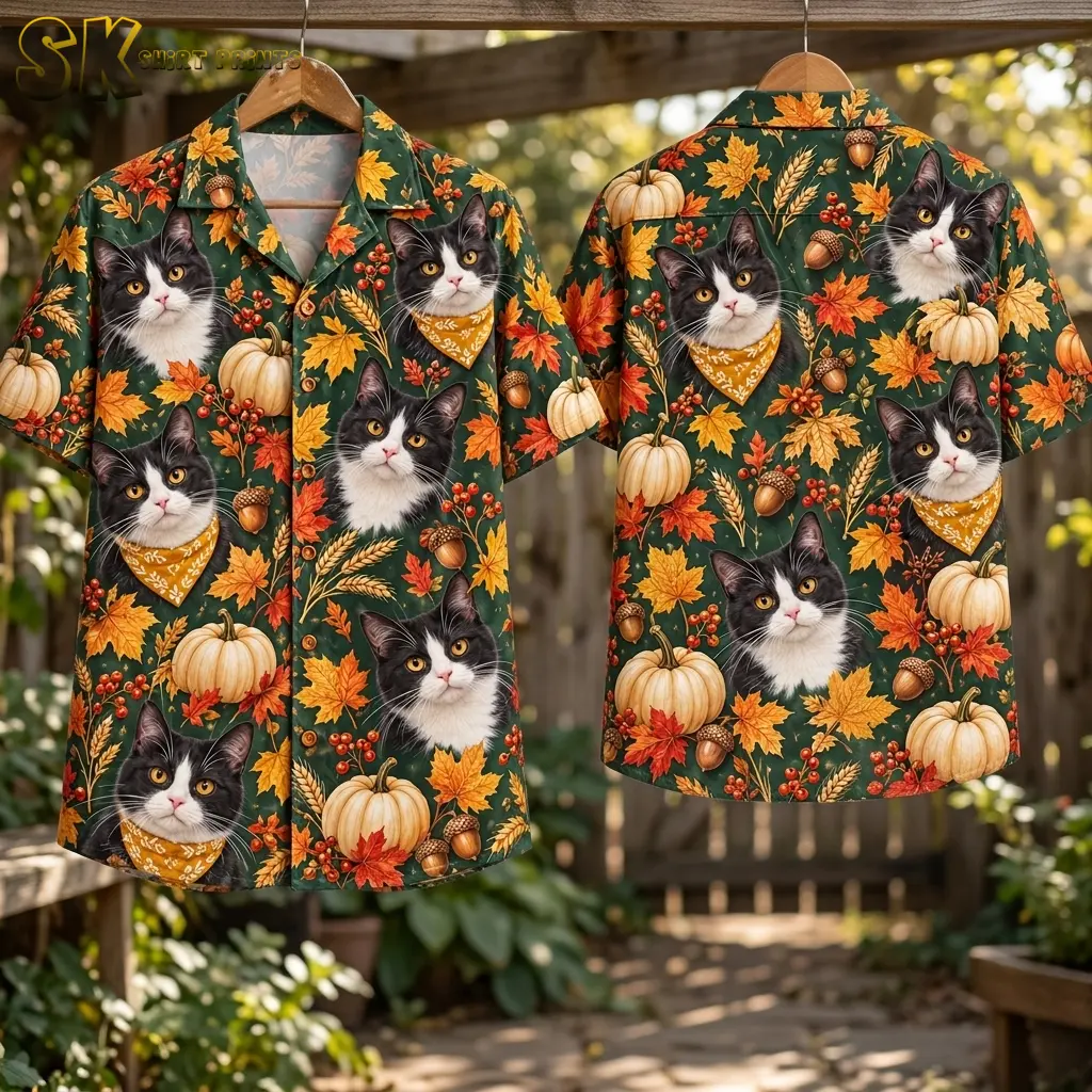 Two green cat-print shirts hang from wooden hangers outdoors, displaying the buttoned front and full patterned back.