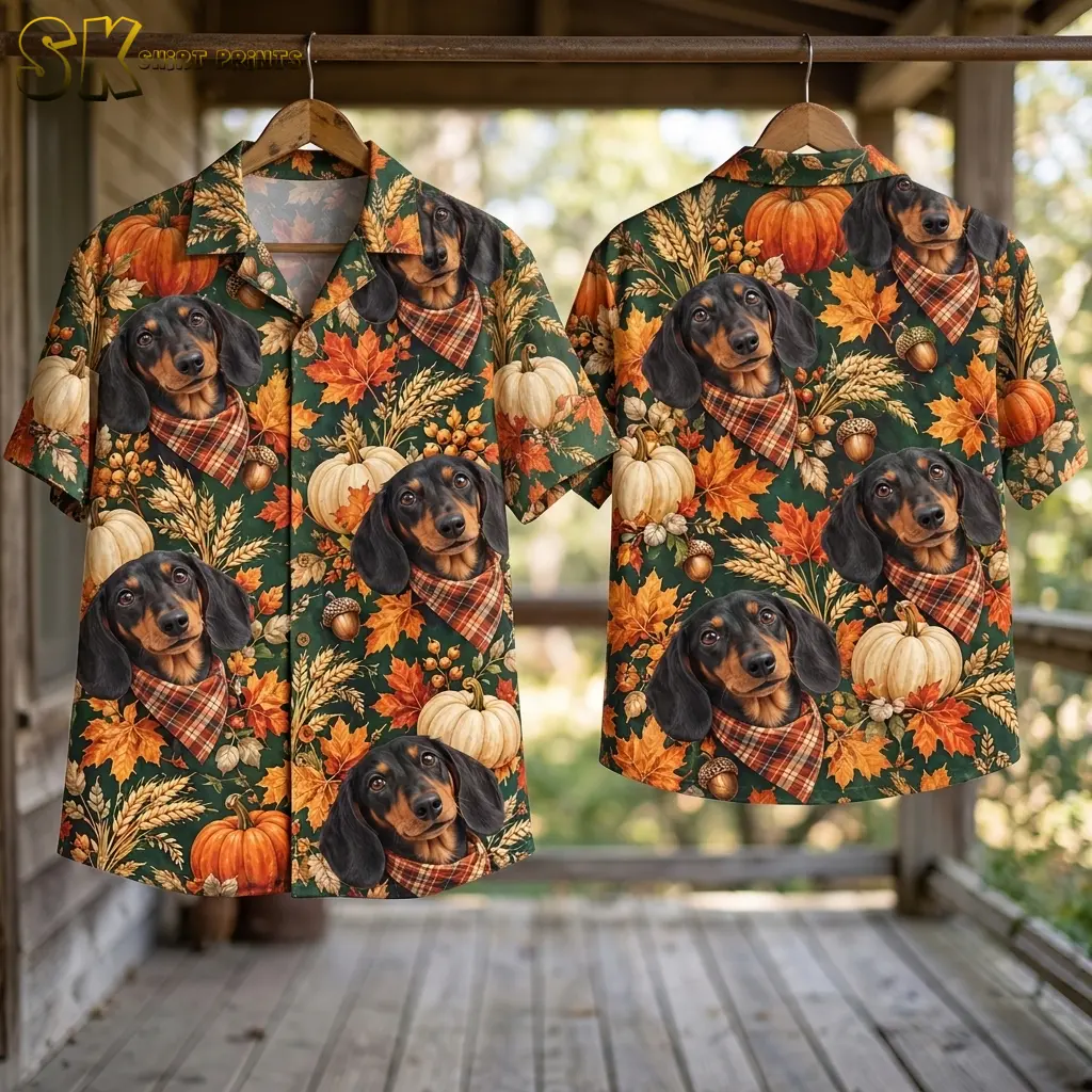 Front and back of the green dachshund and pumpkin shirt hang from wooden hangers on a porch.