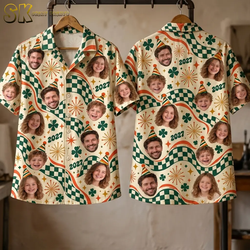 Two cream party-print shirts hang from wooden hangers, showing the buttoned front and back with faces, clovers, and 2027 text.