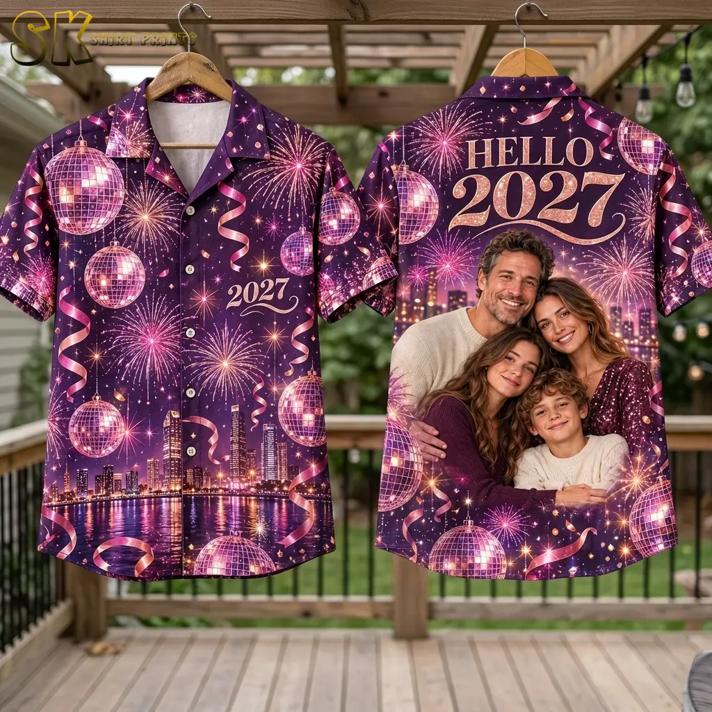 Purple shirts hang front and back on wooden hangers beneath a pergola, showing “2027” on the front and a family portrait on the back.