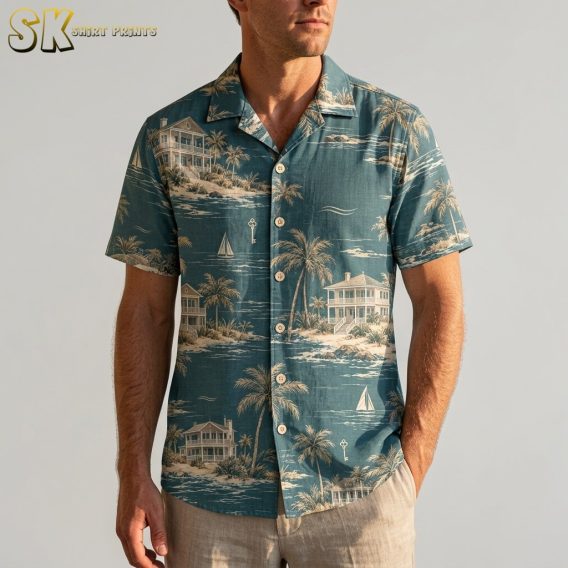 A man wearing the teal coastal Hawaiian shirt stands against a neutral background, with the beige palm tree and beach house print clearly visible across the chest and button placket.