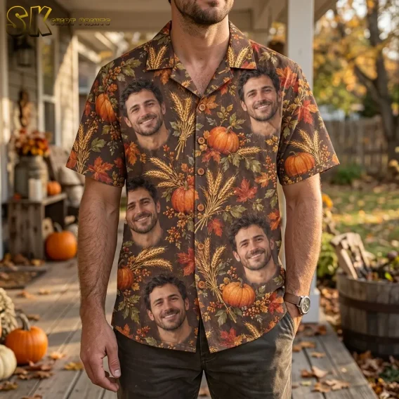 A man stands on a pumpkin-decorated porch wearing a brown Thanksgiving Hawaiian shirt with large smiling faces and autumn harvest motifs.