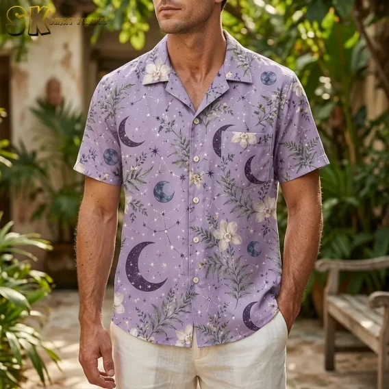 A man standing outdoors in a lush garden setting wearing the lavender celestial shirt, with crescent moons and white floral sprigs clearly visible across the chest and left pocket area.