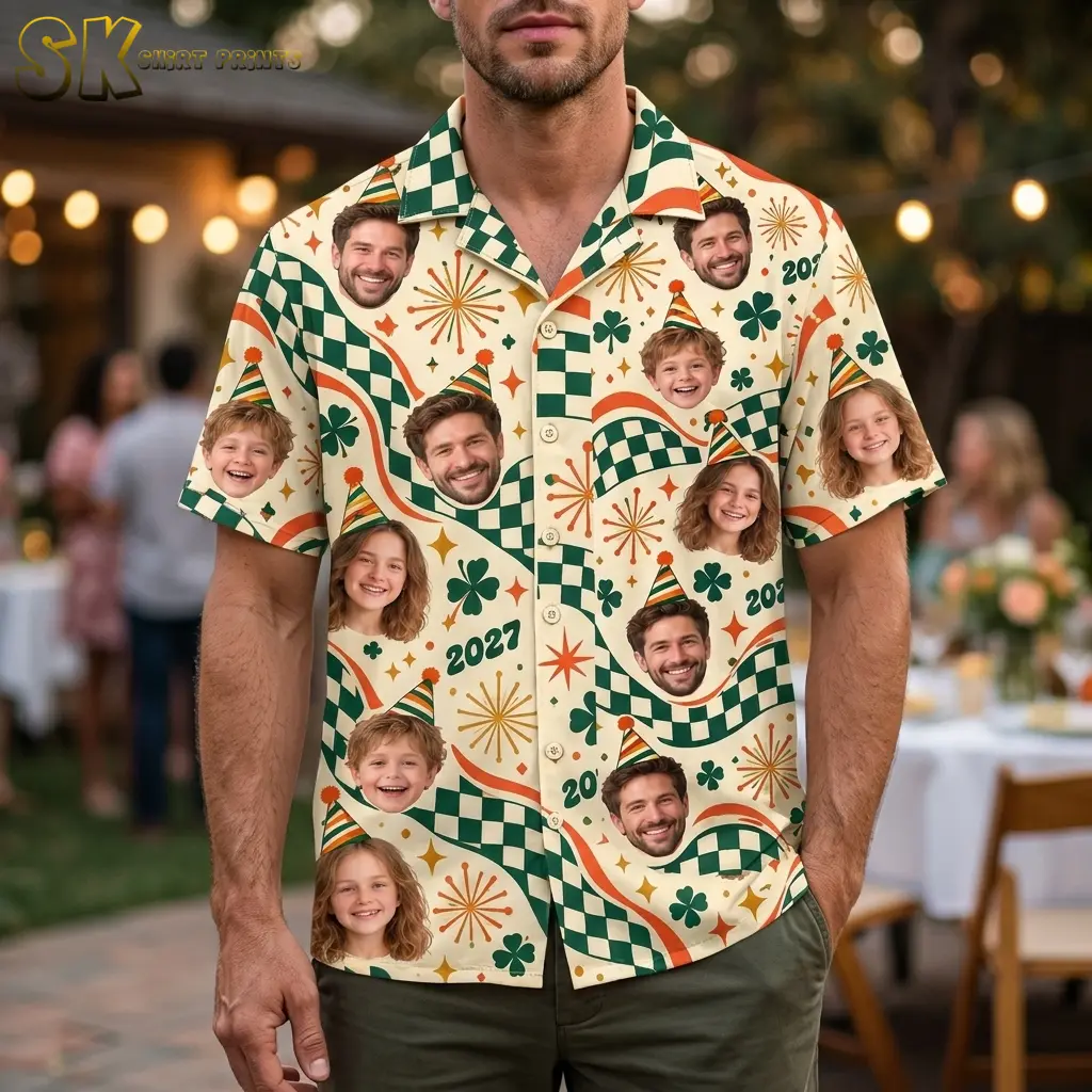 A man wears a cream short-sleeve button-up shirt with repeated faces in party hats and green checkered waves at an outdoor gathering.