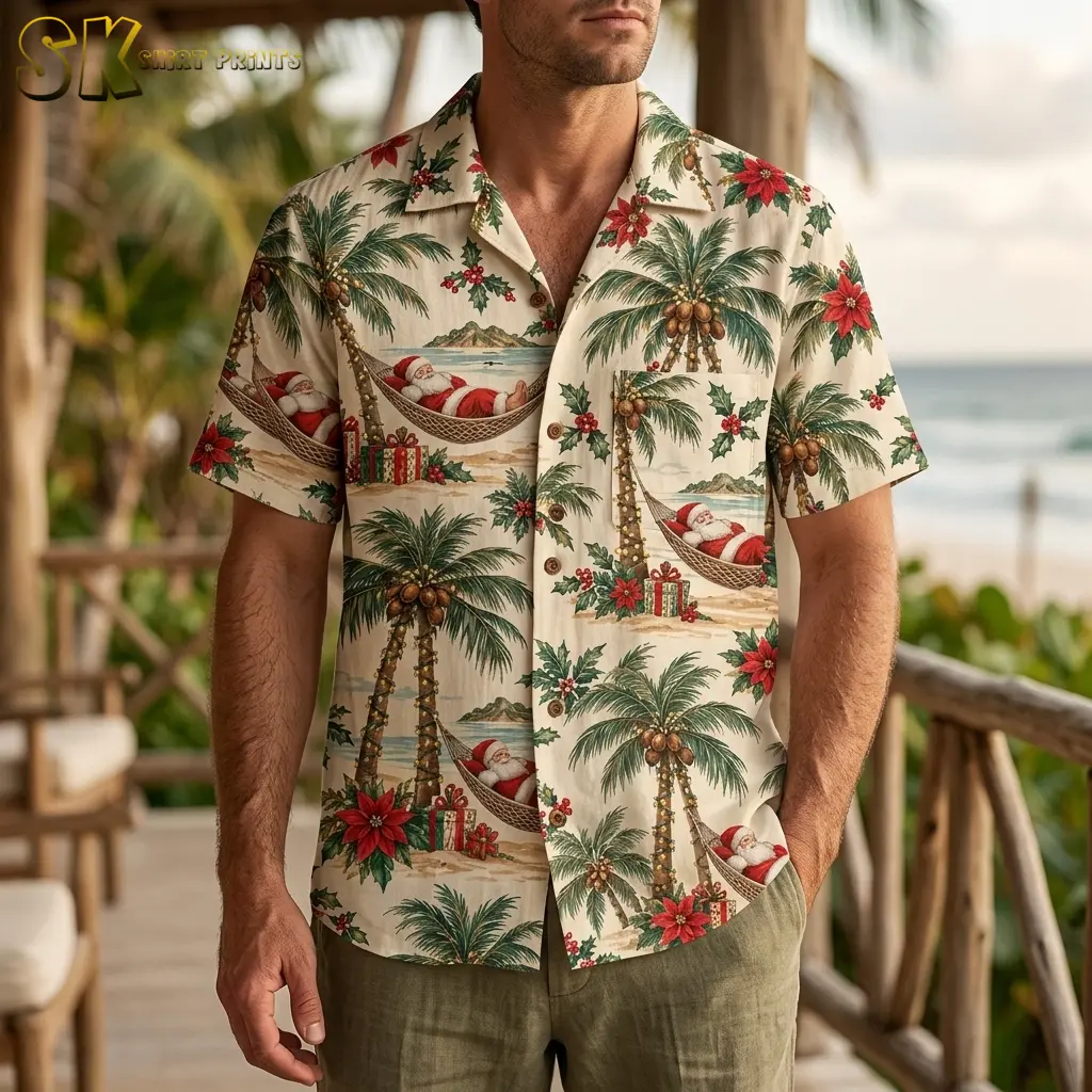 A man wears a cream Santa Claus Hawaiian shirt with olive-colored shorts on a wooden deck overlooking the ocean.