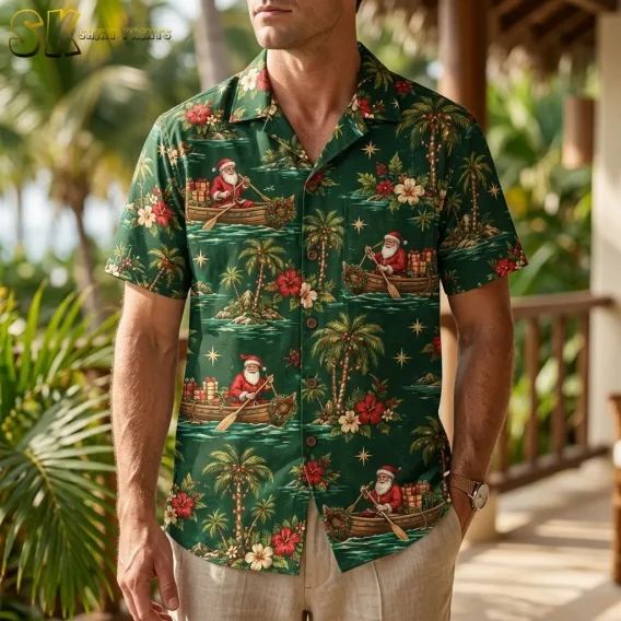 A man wears a green Santa Claus Hawaiian shirt with beige pants on a porch surrounded by tropical greenery.