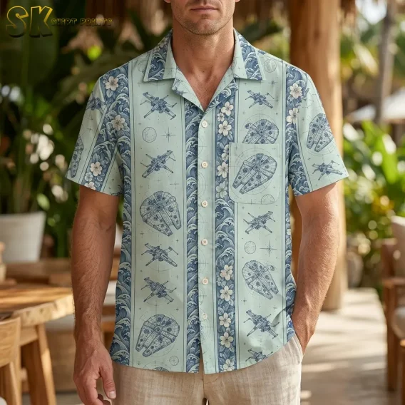 A man wears a seafoam green Star Wars Hawaiian shirt with spacecraft print and beige pants on a plant-filled patio.