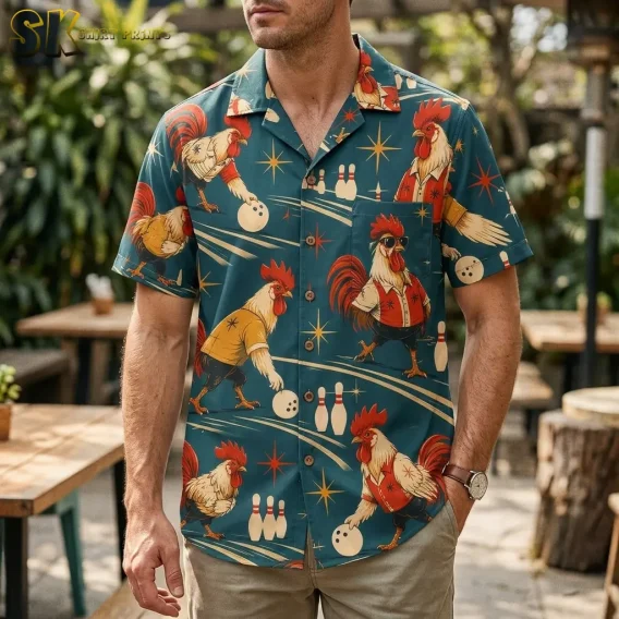 A man wears a teal rooster Hawaiian shirt with beige pants on an outdoor patio with wooden tables and greenery.
