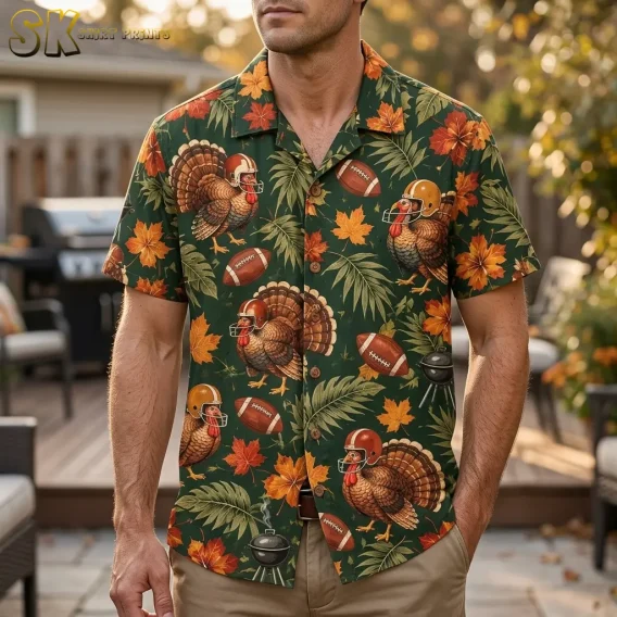 A man wears a dark green Thanksgiving Hawaiian shirt with helmeted turkeys and footballs on a patio, paired with tan pants.