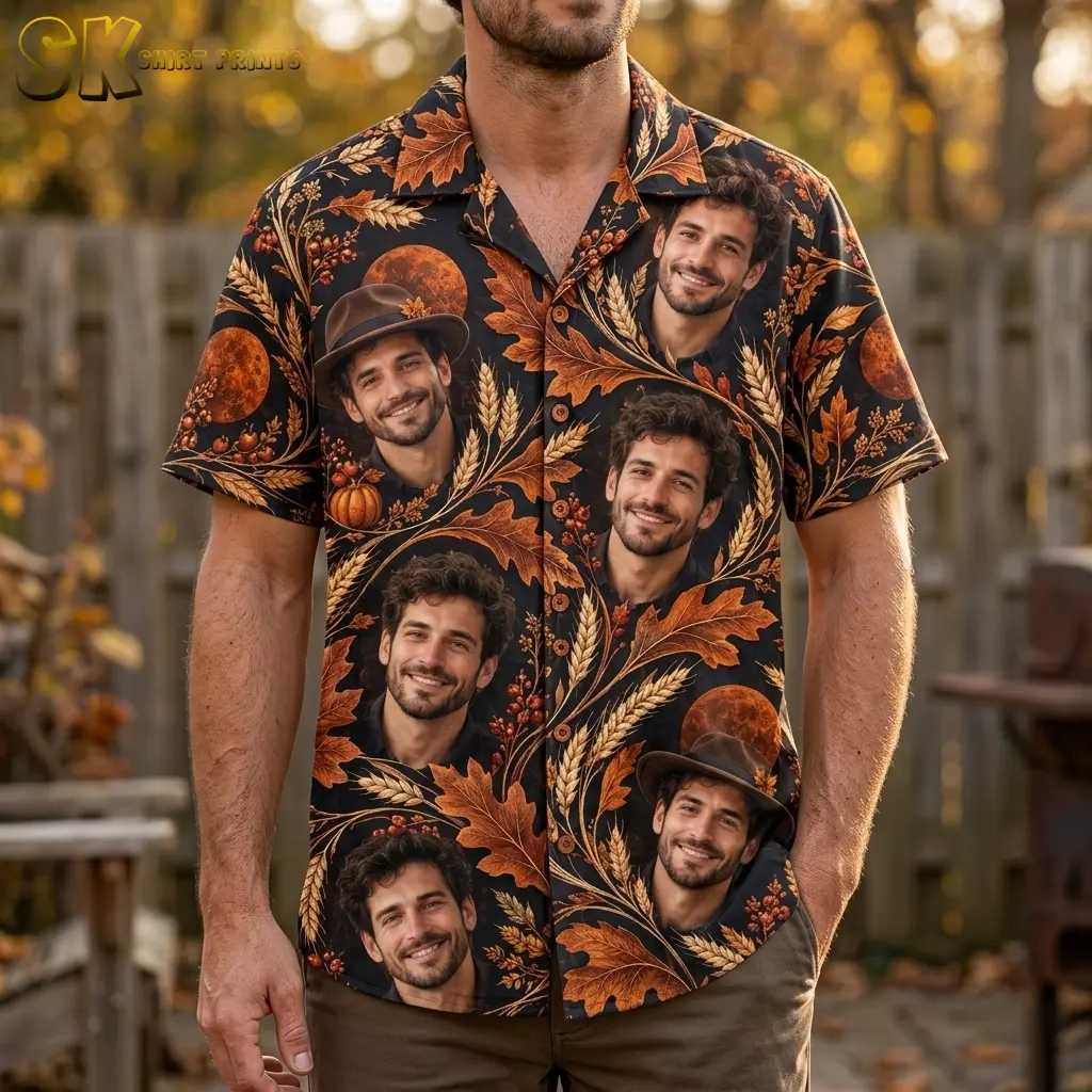 A man wears a black Thanksgiving Hawaiian shirt with large smiling portraits and orange autumn motifs beside a wooden fence.