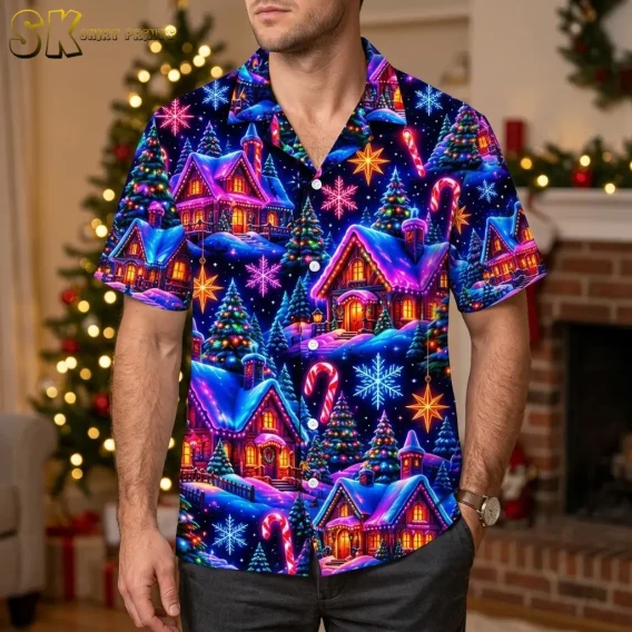 A man wears a Christmas themed Hawaiian shirt with bright cottage and snowflake motifs beside a decorated tree and brick fireplace.