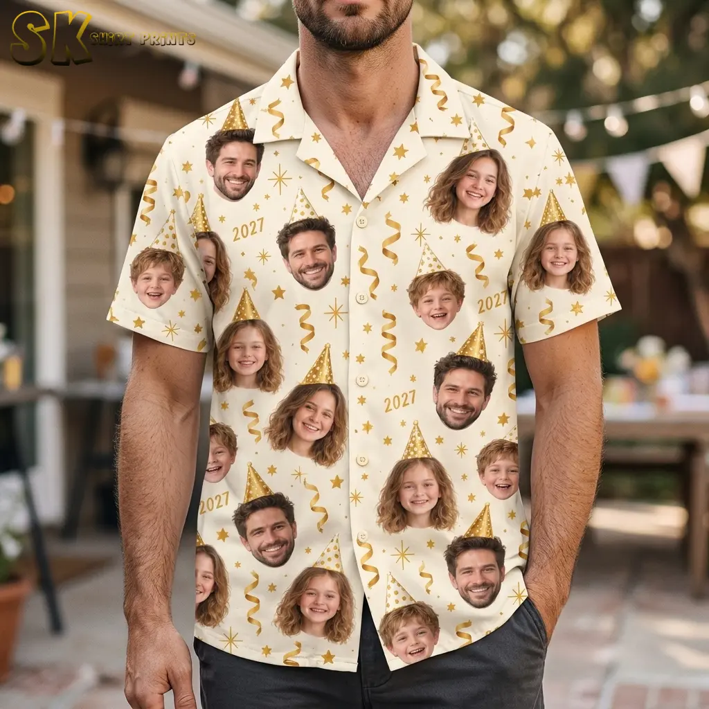 A man wears a cream short-sleeve shirt with face portraits and gold 2027 graphics outdoors beneath string lights.