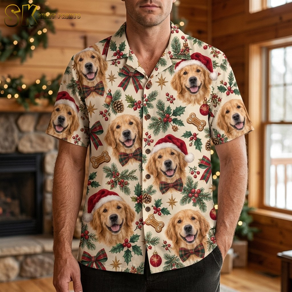 A man wearing christmas hawaiian shirts for men stands in a warmly lit wood-paneled room with a decorated fireplace behind him, the Golden Retriever faces with Santa hats clearly visible across the chest.