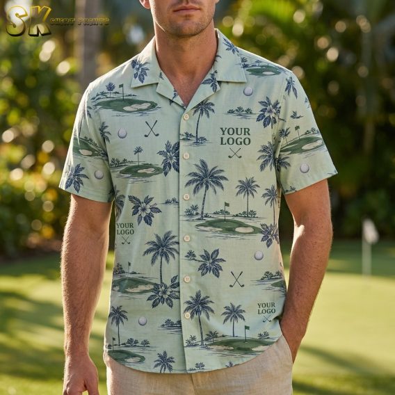 A man stands on a grass golf course wearing a light green logo Hawaiian shirt printed with navy palm trees, putting greens, crossed golf clubs, and golf balls across the entire front.