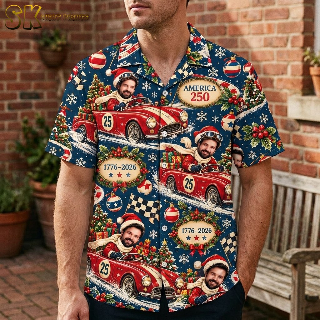 A man wearing the dark blue button-up shirt stands outdoors against a brick wall, showing how the vintage red race car and holiday motifs sit across the chest and torso.
