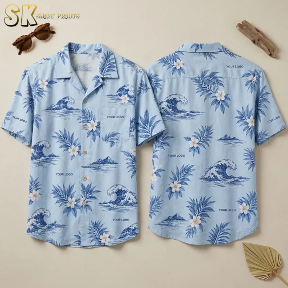 Front and back of a light blue custom Hawaiian shirt with company logo placeholders shown flat on a neutral surface, featuring repeating blue ocean wave, coastal mountain, palm leaf, and white flower motifs with wood-tone buttons.