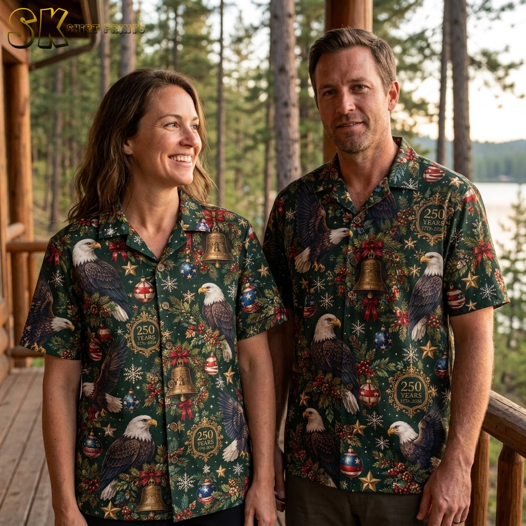 A couple shown together in a lifestyle setting, at least one of them wearing the dark green short-sleeve button-up shirt featuring bald eagles and Christmas-themed decorations.