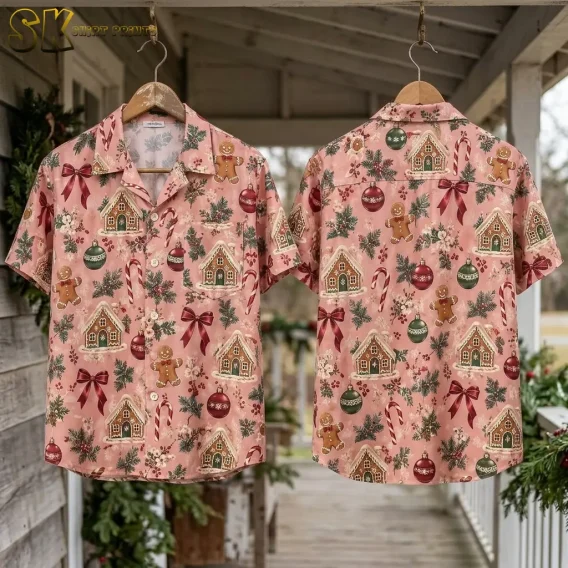 Two xmas hawaiian shirts hung on wooden hangers on a porch decorated with pine garland, displaying the front and back of the pink gingerbread pattern side by side.