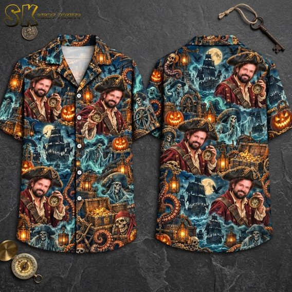 Front and back hanger view of a dark blue short-sleeve button-up shirt printed with a repeated portrait of a bearded pirate holding a compass, a pirate ship under a full moon, ghostly figures, skulls in pirate hats, jack-o'-lanterns, and flying bats.
