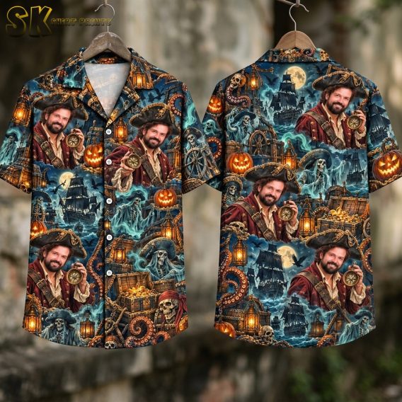 Flat lay showing the front and back of the dark blue short-sleeve shirt side by side, with the pirate ship, ghostly skeletons, treasure chests, tentacles, and bat motifs clearly visible across both panels.