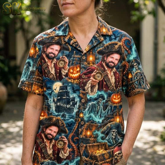 A close-up view on a woman showing the shirt's printed detail, including the bearded pirate portrait holding a compass, glowing lanterns, and skull motifs against the dark blue fabric.