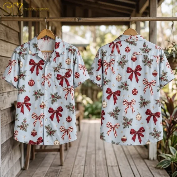 Front and back of a light blue Christmas Hawaiian shirt hang on wooden hangers from a rod on a wooden porch.
