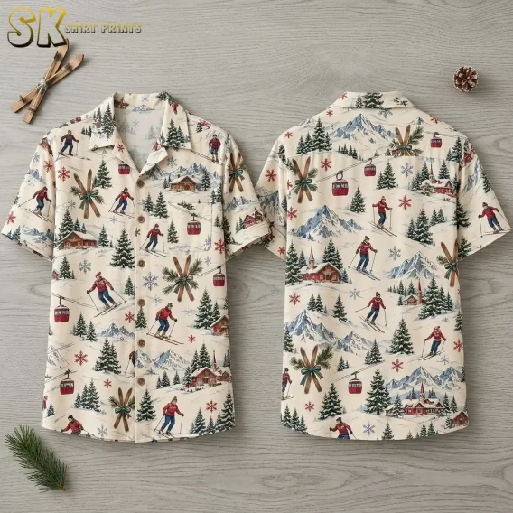 Front and back of a cream christmas aloha shirt laid flat on a light wood surface, showing skiers in red tops, red gondola cabins, crossed wooden skis with pine branches, and snowflakes across the full pattern.