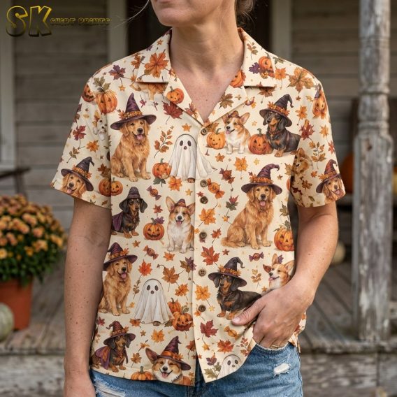 Close-up of a woman wearing a cream spooky hawaiian shirt, showing detailed illustrations of dogs in witch hats and ghost costumes alongside carved pumpkins and orange leaves.