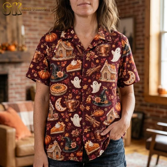 Close-up of a woman wearing a burgundy spooky hawaiian shirt showing detailed gingerbread houses, white ghosts, crescent moons, and floral accents.