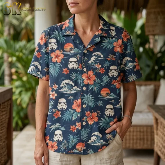 A woman wearing the star wars tropical shirt photographed from the chest up, with the sci-fi helmet motifs and large orange hibiscus blooms shown in sharp detail across the fabric.