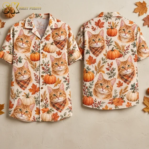 Front and back of a cream button-up shirt display orange tabby cats, pumpkins, and fall leaves against a beige background.