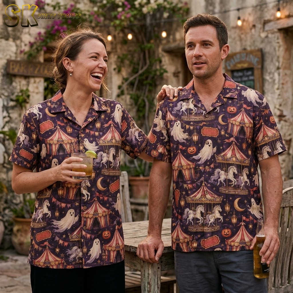 A couple wearing the Halloween carnival-themed shirt in a lifestyle setting, with the dark base and muted pink, cream, and soft gold motifs visible across both wearers.