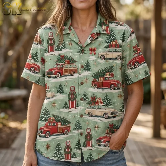 A woman outdoors wears the christmas hawaiian shirt, with the beige vintage station wagon, red pickup truck, and golden starburst motifs filling the frame at close range.