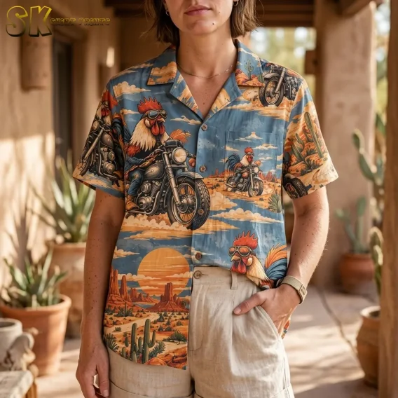 A woman wears a blue rooster Hawaiian shirt partly tucked into beige shorts, showing the collar, chest pocket, and motorcycle print.