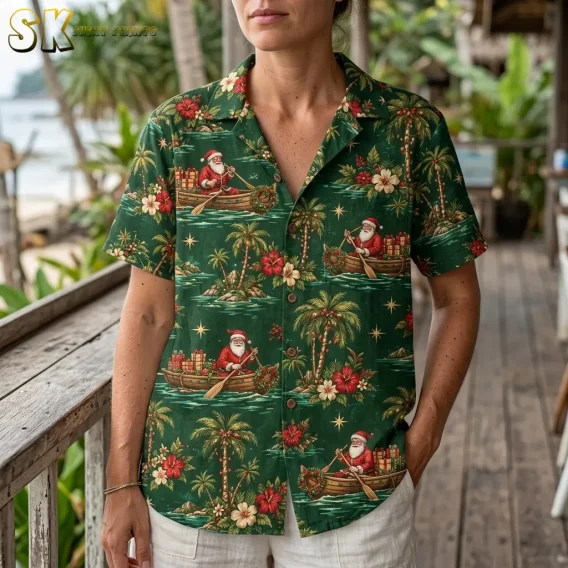 A woman wears a green Santa aloha shirt with white shorts beside a wooden railing, showing the collar and festive boat print.