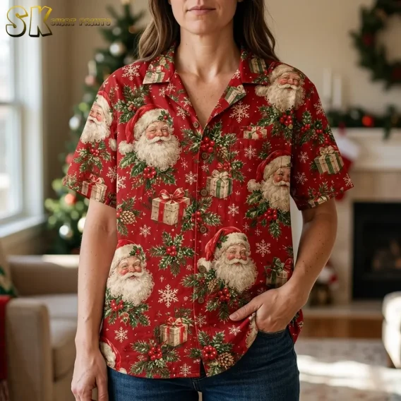 A woman wears a red Santa aloha shirt with dark jeans indoors, with Santa faces and wrapped gifts visible across the front.