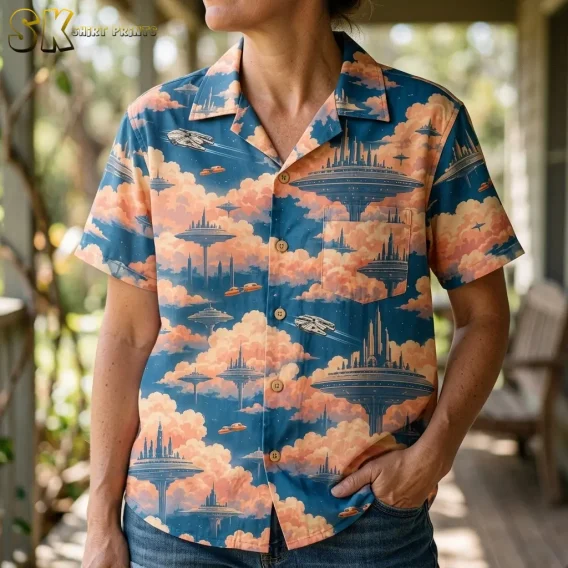 A woman wears a blue and peach sci-fi button-up shirt with jeans, showing the collar, chest pocket, and spacecraft print in close-up.