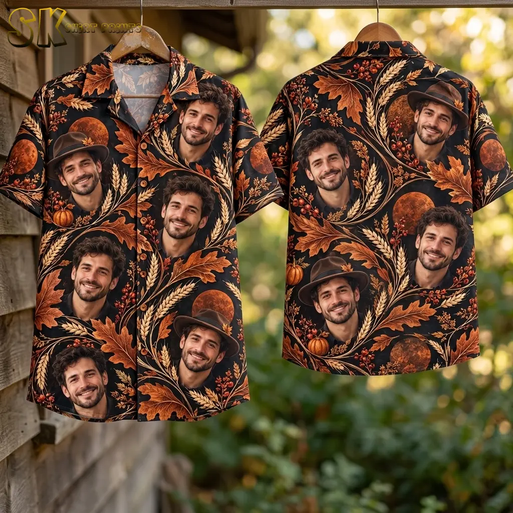 Front and back of a black autumn-print shirt hang from wooden hangers outdoors, showing portraits, pumpkins, and orange moon motifs.