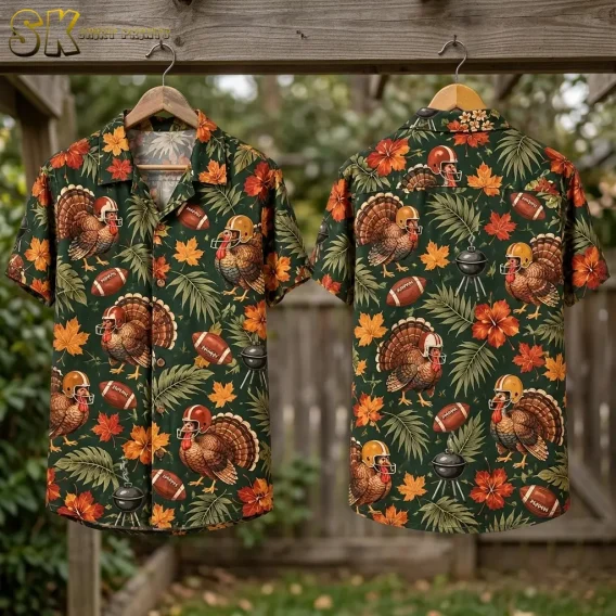 Front and back of a green turkey-print shirt hang from wooden hangers beneath an outdoor beam, with foliage in the background.